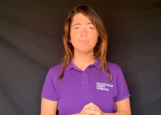 Woman with brown hair wearing SignHealth purple polo shirt