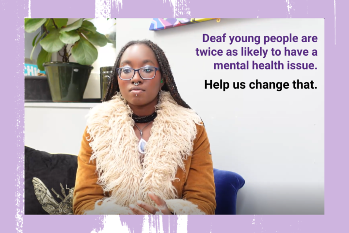 Young black woman with long dark hair wearing a coat sat on blue armchair, surrounded by plants and the words, deaf young people are twice as likely to have a mental health issue. Help us change that.