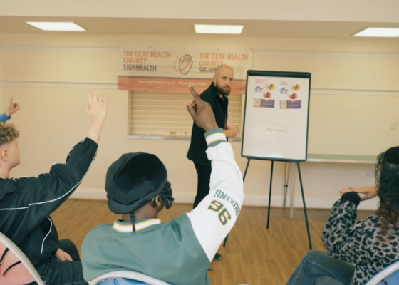 Young people sitting raising their hands with ideas