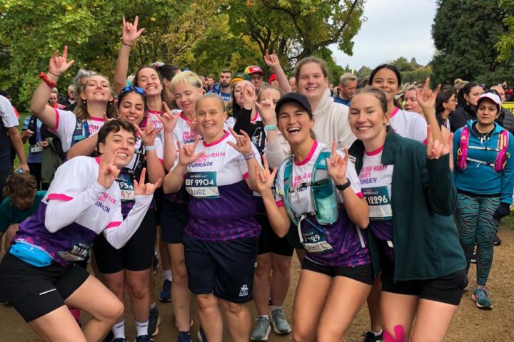 women standing together wearing SignHealth running tops and signing 'love'