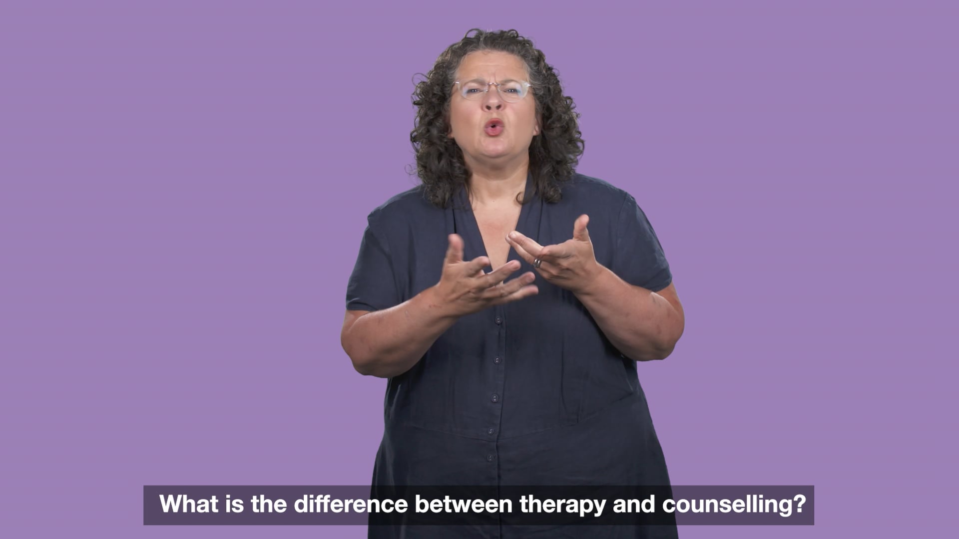woman wearing dark shirt signing with light purple background