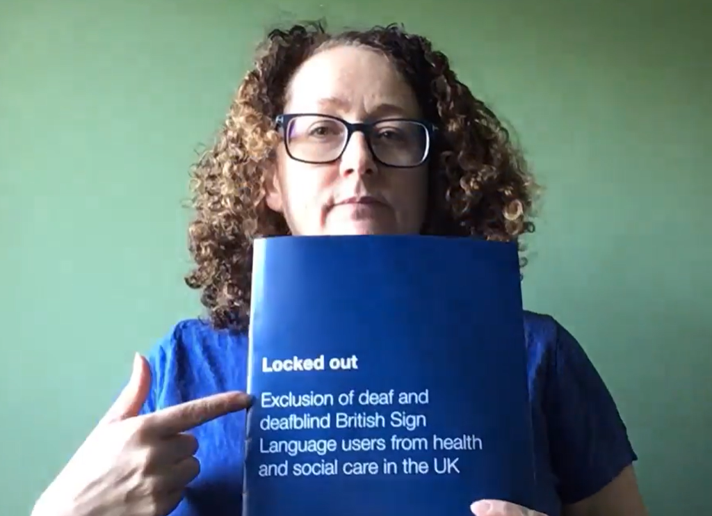 white female with long brown curly hair holding up blue 'locked out' leaflet