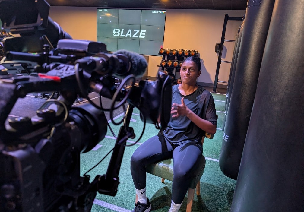 Woman signing to large tv camera